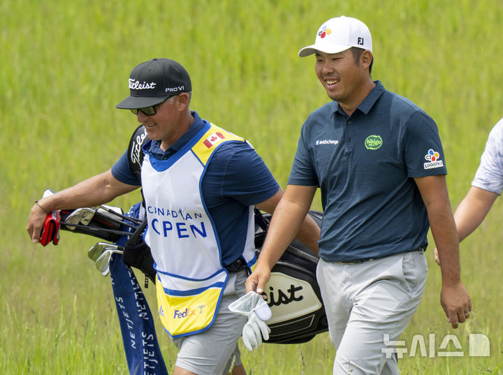 [칼레돈=AP/뉴시스] 안병훈(오른쪽)이 8일(현지 시간) 캐나다 온타리오주 칼레돈 TPC 토론토 앳 오스프라이 밸리에서 열린 미국프로골프(PGA) 투어 RBC 캐나다오픈 최종 라운드 5번 홀 페어웨이에서 캐디와 함께 걸으며 미소 짓고 있다. 안병훈은 최종 합계 15언더파 265타 공동 6위로 대회를 마쳤다. 2025.06.09.
