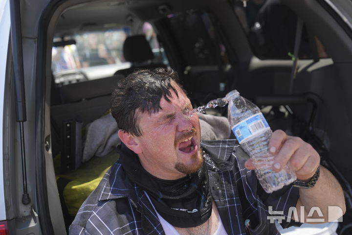 [로스앤젤레스=AP/뉴시스] 8일(현지 시간) 미 캘리포니아주 로스앤젤레스 도심에서 이민세관단속국(ICE)의 불법 이민자 단속 및 체포에 항의하던 시위 참가자가 물로 최루 가스를 씻어내고 있다. 도널드 트럼프 대통령은 불법 이민자 단속에 항의하는 시위에 참여하는 사람들은 마스크를 착용해서는 안 된다고 밝혔다. 2025.06.09.