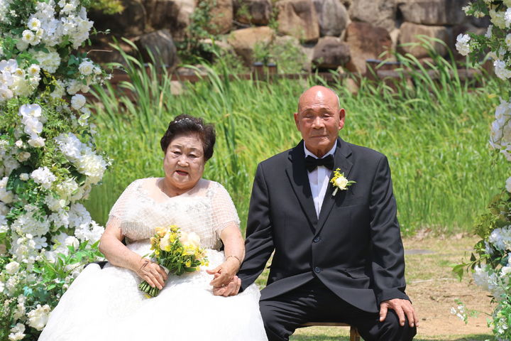 [대구=뉴시스] 지난 7일 대구 동구 팔공산 갓바위 자생식물원에서 국가유공자 부부가 뒤늦은 결혼식을 올리고 있다. (사진=국립공원공단 팔공산국립공원동부사무소 제공) 2025.06.09. photo@newsis.com *재판매 및 DB 금지