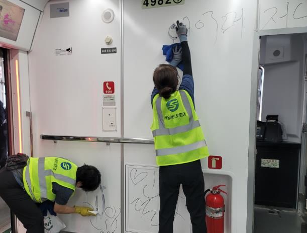 [서울=뉴시스] 4호선 열차 내 불법낙서를 지우는 관계 직원들. 2025.06.09 (사진 제공=서울교통공사) photo@newsis.com *재판매 및 DB 금지