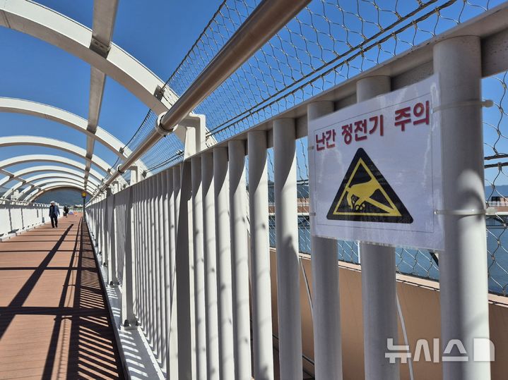 [부산=뉴시스] 김민지 기자 = 5일 오전 부산 도시철도 3호선 구포역과 화명생태공원을 연결하는 보행교 '감동나룻길 리버워크'에 난간 정전기 발생을 주의하는 안내문이 걸려 있다. 2025.06.09. mingya@newsis.com