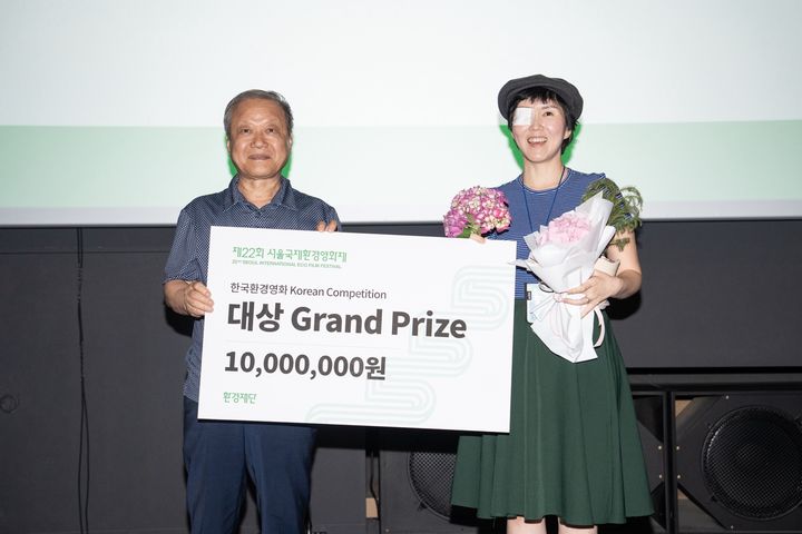 [서울=뉴시스] 제22회 서울국제환경영화제 한국경쟁 대상을 수상한 다큐멘터리 종이 울리는 순간의 김주영 감독이 기념 사진을 촬영하고 있다. (사진=서울국제환경영화제) 2025.06.09. photo@newsis.com&nbsp; *재판매 및 DB 금지