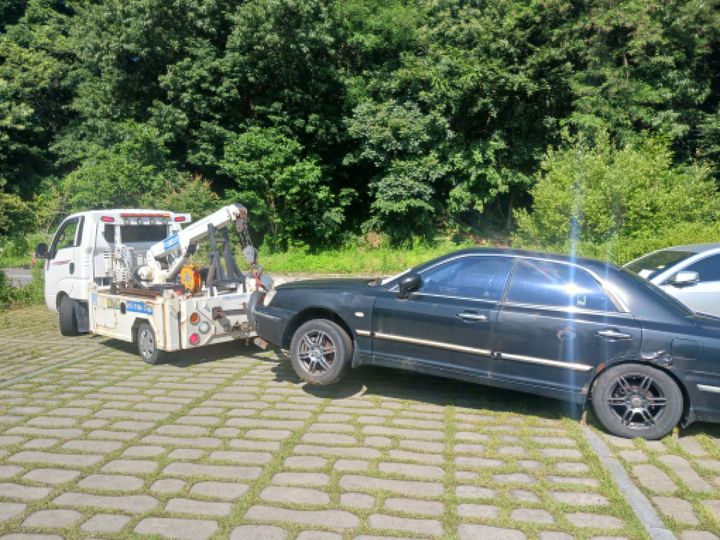 [광주=뉴시스] 광주 서구가 무료 공영주차장에 장기 방치된 차량을 강제 견인 조치하고 있다.(사진=광주 서구 제공). photo@newsis.com *재판매 및 DB 금지 *재판매 및 DB 금지