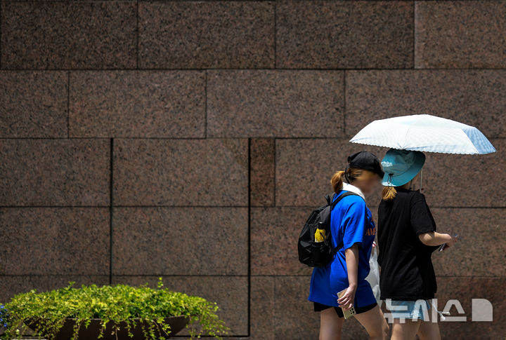 [서울=뉴시스] 정병혁 기자 = 더운 날씨를 보인 9일 서울 강남구 코엑스 인근에서 한 시민이 양산으로 햇빛을 가린 채 이동하고 있다. 2025.06.09. jhope@newsis.com