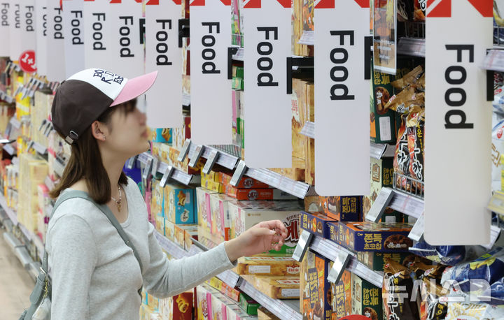 한 대형마트에서 소비자들이 과자 등을 고르고 있다.통계청 국가통계포털(KOSIS)에 따르면 지난달 가공식품 74개 품목 가운데 윤석열 대통령의 비상계엄 사태 직전인 지난해 11월 대비 물가지수가 상승한 품목은 52개로 전체의 71.2%를 차지했다. 특히 초콜릿이 10.4%, 커피는 8.2% 상승했다. 양념 소스와 식초, 젓갈등도 7% 넘게 올랐다. 2025.06.09. hwang@newsis.com