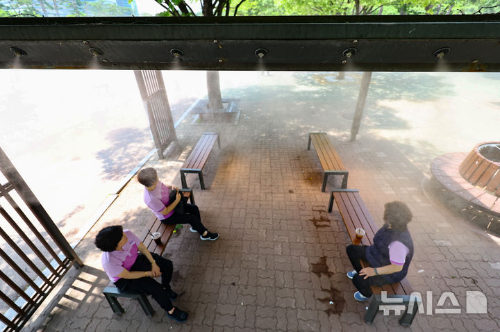 [서울=뉴시스] 황준선 기자 = 한낮 기온이 30도를 넘는 무더운 날씨를 보인 9일 오후 서울 여의도공원에서 시민들이 쿨링포그를 맞으며 휴식을 취하고 있다. 2025.06.09. hwang@newsis.com