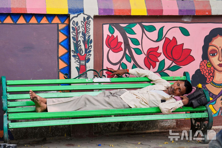<font style="vertical-align: inherit;"><font style="vertical-align: inherit;">[인도=AP/뉴시스] 10일(현지 시간) 인도 북부 우타르프라데시 주 프라야그라지에서 한 남성이 벤치에서 잠을 자고 있다. 2025.06.12.</font></font>