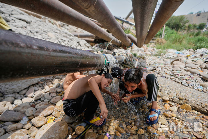 <font style="vertical-align: inherit;"><font style="vertical-align: inherit;">[인도=AP/뉴시스] 10일(현지 시간) 인도 잠무에서 어린이들이 파이프에서 새는 물을 맞으며 더위를 식히고 있다. 2025.06.12.</font></font>