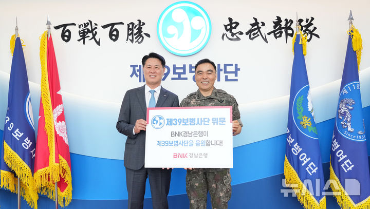 [창원=뉴시스]BNK경남은행 김태한(왼쪽) 은행장이 10일 부대창설 70주년을 맞은 육군 제39보병사단 사령부를 방문해 김종묵 사단장에게 위문금을 전달하고 있다.(사진=BNK경남은행 제공) 2025.06.10. photo@newsis.com