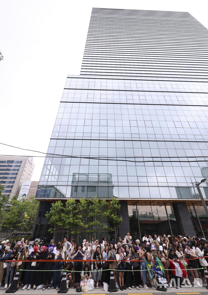 [서울=뉴시스] 김근수 기자 = 방탄소년단(BTS) 멤버 RM, 뷔의 전역날인 10일 오전 서울 용산구 하이브 사옥 앞에서 방탄소년단(BTS) 팬들이 멤버들의 제대를 축하하며 노래를 부르고 있다. 2025.06.10. ks@newsis.com