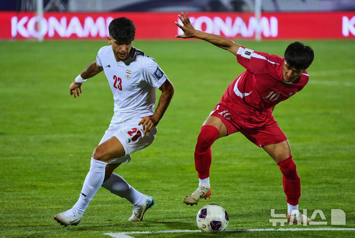 [테헤란=AP/뉴시스] 북한의 리일송(오른쪽)이 10일(현지 시간) 이란 테헤란 아자디 스타디움에서 열린 2026 국제축구연맹(FIFA) 북중미 월드컵 아시아 3차 예선 A조 최종 10차전 이란과 경기 중 공을 다투고 있다. 북한은 0-3으로 완패해 3무7패(승점3)로 탈락했다. 2025.06.11.