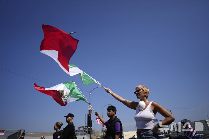 [로스앤젤레스=AP/뉴시스] 10일(현지 시간) 미 캘리포니아주 로스앤젤레스에서 멕시코 국기를 든 시위대가 이민세관단속국(ICE)의 불법 이민자 단속을 규탄하고 있다. 2025.06.11.