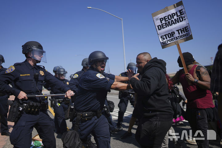 [로스앤젤레스=AP/뉴시스] 10일(현지 시간) 미 캘리포니아주 로스앤젤레스에서 캘리포니아 고속도로 순찰대 소속 경찰관들이 불법 이민자 단속에 반대하는 시위대와 충돌하고 있다. 2025.06.11.