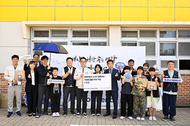 [울산=뉴시스] 현대자동차 노사 관계자들이 11일 울산 북구 양정초등학교에서 지역 초등학생들을 위한 1억원 상당의 친환경 물품 키트를 전달하고 있다. (사진=현대자동차 제공) 2025.06.11. photo@newsis.com *재판매 및 DB 금지