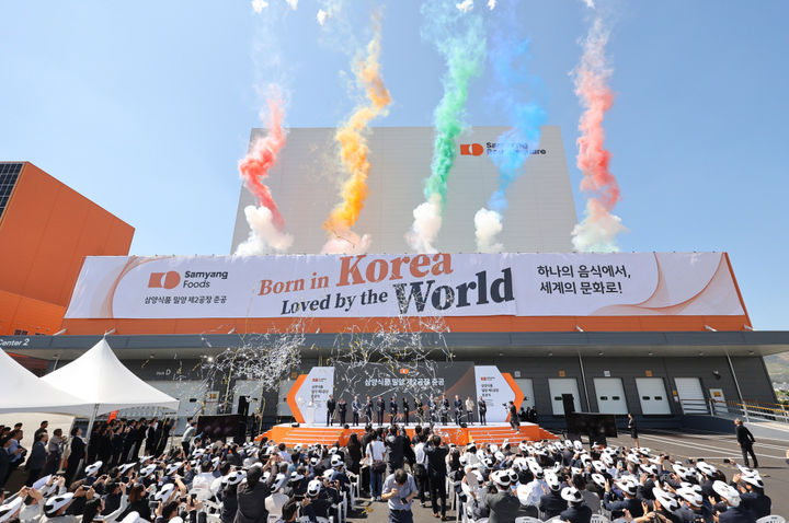 [서울=뉴시스] 김정수 삼양식품 부회장이 11일 경남 삼양식품 밀양캠퍼스에서 열린 밀양 제2공장 준공식에 참석해 참석자들과 세리머니를 하고 있다. 삼양식품은 연면적 3만 2989㎡, 지하 1층, 지상 3층 규모의 밀양 2공장을 준공했다. 해외 수출용 제품을 생산하는 제2공장이 가동되면 미국과 멕시코, 유럽 등 주요 해외시장에 대한 초과 수요 대응이 가능할 것이라는 전망이다. (사진=삼양식품 제공) 2025.06.11. photo@newsis.com *재판매 및 DB 금지