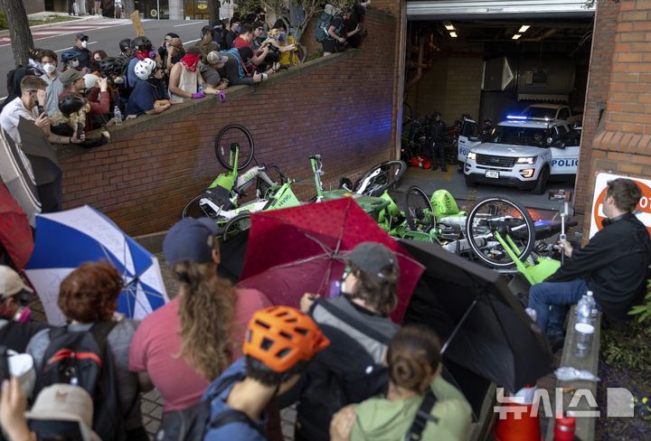 [시애틀=AP/뉴시스] 지난 10일(현지 시간) 미 워싱턴주 시애틀의 헨리 M. 잭슨 연방 청사 건물 주차장을 봉쇄한 연방 보호국 경관들이 출구에 모여 있는 시위대와 대치하고 있다. 2025.06.12.