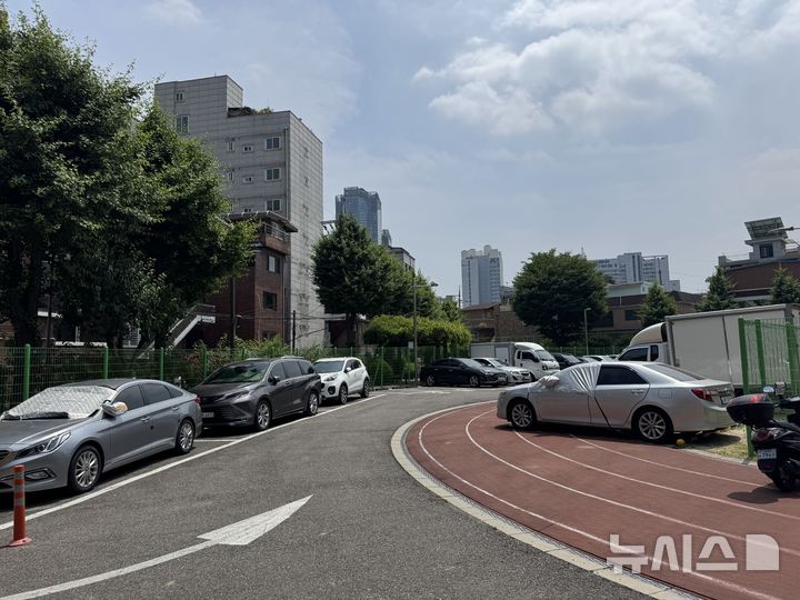 [서울=뉴시스]]김지윤 인턴기자 = 서울 광진구 화양초등학교 전경. 2023년 폐교된 이후 2년째 방치 중인 이 부지는 현재 임시 주차장으로 활용되고 있다. 사진은 화양초 운동장 한편에 차량 수대가 주차돼 있는 모습. 2025.06.12