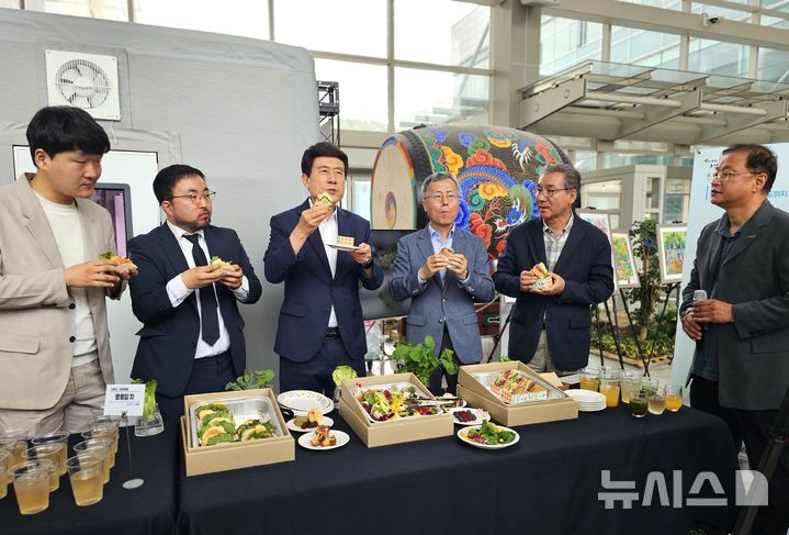 [포항=뉴시스] 송종욱 기자 = 12일 경북 포항시청 솔라갤러리 인도어팜전시장에서 열린 '인도어팜 수확물 시식회'에서 황홍섭(왼쪽부터) (주)딜라이트푸드 대표, 서충모 (주)미드바르 대표, 이강덕 포항시장, 배영호 (재)포항테크노파크 원장, 김진근 포항시 신활력플러스추진단장이 인도어팜에서 생산한 재료로 만든 샌드위치를 먹고 있다. 2025.06.12. sjw@newsis.com
