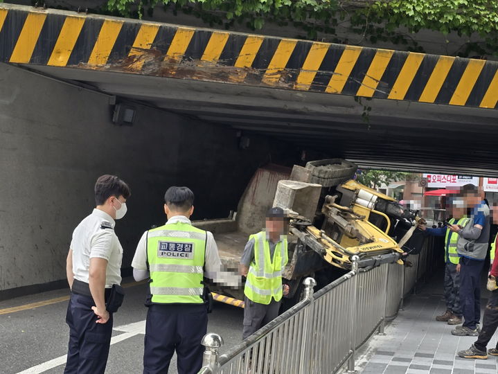 [부산=뉴시스] 12일 낮 12시께 부산 부산진구 부전제1가도교에서 1t 화물차가 미니굴삭기를 싣고가던 중 높이 제한에 걸려 굴삭기가 옆으로 넘어지는 사고가 발생했다. (사진=부산경찰청 제공) 2025.06.12. photo@newsis.com *재판매 및 DB 금지