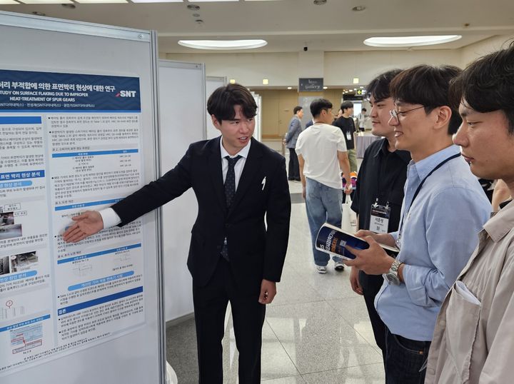 [창원=뉴시스] 강경국 기자 = 박성호 SNT다이내믹스 엔지니어(왼쪽)가 11일 한국군사과학기술학회 종합학술대회에서 연구논문을 발표하고 있다. (사진=SNT다이내믹스 제공). 2025.06.12. photo@newsis.com *재판매 및 DB 금지