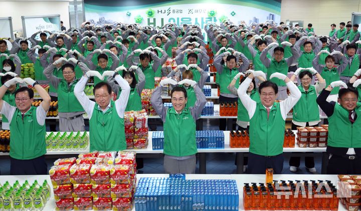 [부산=뉴시스] 하경민 기자 = HJ중공업 유상철 대표이사 등 임직원 200여 명이 12일 오전 부산 영도구 영도조선소 구내식당에서 저소득가정에 전달할 생필품 선물꾸러미를 포장하기에 앞서 하트 모양을 만들고 있다. HJ중공업은 쌀, 된장, 간장, 식용유, 라면, 치약, 샴푸, 비누, 세제, 고무장갑 등 4000만원 상당의 생필품 선물꾸러미 1000개를 만들어 홀몸노인과 소년소녀가정 등 복지사각지대에 놓인 저소득가정 1000가구에 전달할 예정이다. 2025.06.12. yulnetphoto@newsis.com