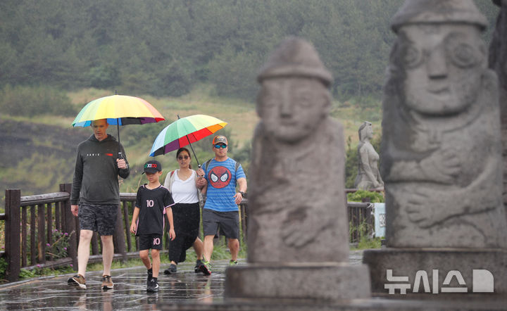 [서귀포=뉴시스] 우장호 기자 = 올해 첫 장맛비가 내리는 12일 오전 제주 서귀포시 대정읍 송악산 둘레길에서 우산을 쓴 관광객들이 걸어가고 있다. 2025.06.12. woo1223@newsis.com