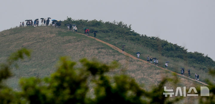 [제주=뉴시스] 우장호 기자 = 지난달 12일 오후 제주시 애월읍 봉성리 새별오름 정상에서 우산을 쓴 수학여행단 학생들이 추억을 쌓고 있다. 2025.06.12. woo1223@newsis.com