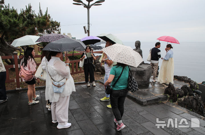 [제주=뉴시스] 우장호 기자 = 올해 첫 장맛비가 내리는 12일 오후 제주 도내 대표적인 관광지 용두암을 찾은 내·외국인 방문객이 우산을 쓴 채 관광 일정을 소화하고 있다. 2025.06.12. woo1223@newsis.com