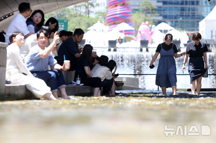 [서울=뉴시스] 홍효식 기자 = 서울 낮 최고기온이 31도까지 오른 12일 서울 중구 청계천 모전교 아래에서 시민들이 발을 담그며 더위를 식히고 있다. 2025.06.12. yesphoto@newsis.com