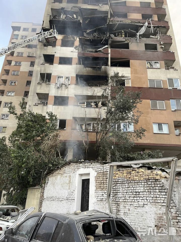 [테헤란=AP/뉴시스] 13일(현지 시간) 이란 테헤란에서 소방관들이 이스라엘의 공습으로 파손된 아파트 건물 화재를 진압하고 있다. 이스라엘방위군(IDF)은 이날 새벽 이스라엘이 이란의 핵·군 시설에 대한 선제타격을 개시했다고 성명을 통해 밝혔다. 2025.06.13.