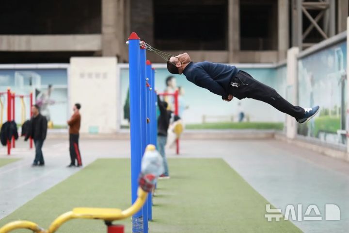 [뉴시스]중국 선양의 노년층 사이에서 밴드에 턱을 걸어 그네를 타는 듯한 수면 요법이 유행처럼 번지고 있다. (사진=뉴욕포스트) 