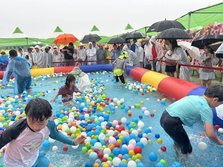 [고창=뉴시스] 13일 고창 심원 마돌어촌체험아을에서 유네스코 세계자연유산을 몸으로 즐기는 '2025 고창 갯벌축제'가 개막했다. 빗속에서도 맨손 장어잡기의 원조인 이 축제의 '미끌미끌 풍천장어 맨손잡기'에 많은 관광객이 참여하고 있다. *재판매 및 DB 금지
