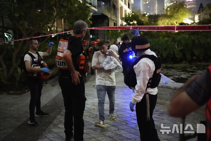 [텔아비브=AP/뉴시스] 13일(현지 시간) 이스라엘 텔아비브에서 구급대원들이 이란이 발사한 미사일에 맞은 건물에서 주민들이 대피하고 있다. 2025.06.14.