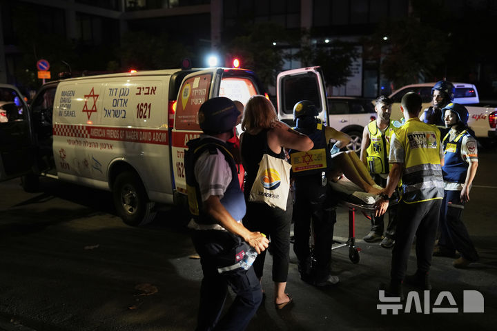 [텔아비브=AP/뉴시스] 6월13일 이스라엘 텔아비브에서 구급대원들이 이란이 발사한 미사일에 맞은 건물에서 부상자를 대피시키고 있다. 2025.06.15.