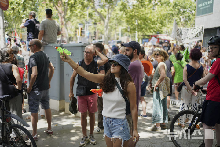 [바르셀로나=AP/뉴시스] 15일(현지 시간) 스페인 바르셀로나에서 오버투어리즘(과잉 관광)에 항의하는 시위가 열린 가운데 한 참가자가 물총을 쏘고 있다. 2025.06.16.