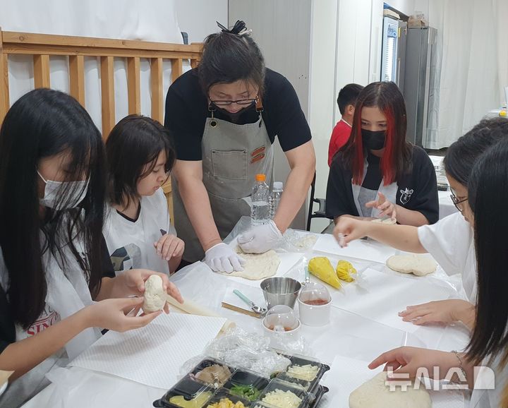 [창원=뉴시스]경남이주민센터 중도입국 및 다문화 청소년 대상 진로탐색 지원사업에 참여한 청소년들이 지난 14일 창원시 성산구 쿠킹아트 창원점에서 '파티시에(제과사)' 직업 체험 활동을 하고 있다.(사진=경남이주민센터 제공) 2025.06.15. photo@newsis.com