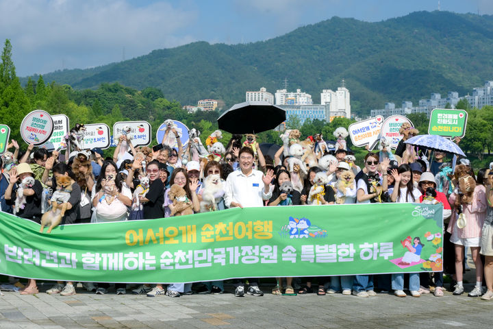 [순천=뉴시스] 15일 전남 순천시 순천만국가정원에서 펫데이 이벤트가 열린 가운데 반려인과 반련견이 기념사진을 찍고 있다. (사진=순천시 제공) 2025.06.15. photo@newsis.com *재판매 및 DB 금지