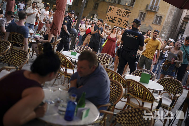 <font style="vertical-align: inherit;"><font style="vertical-align: inherit;">[마요르카=AP/뉴시스] 15일(현지 시간) 스페인 마요르카에서 오버투어리즘(과잉 관광)에 반대하는 시위가 열린 가운데 관광객들이 이를 지켜보고 있다. 2025.06.16.</font></font>