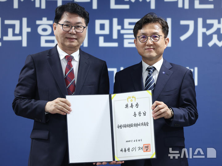 [서울=뉴시스] 김진아 기자 = 이한주(왼쪽) 국정기획위원회 위원장이 16일 서울 종로구 정부서울청사 창성동 별관에서 열린 출범식에서 사회2분과장을 맡은 홍창남 부산대 부총장에게 위촉장을 수여한 뒤 기념촬영을 하고 있다. (공동취재) 2025.06.16. photo@newsis.com
