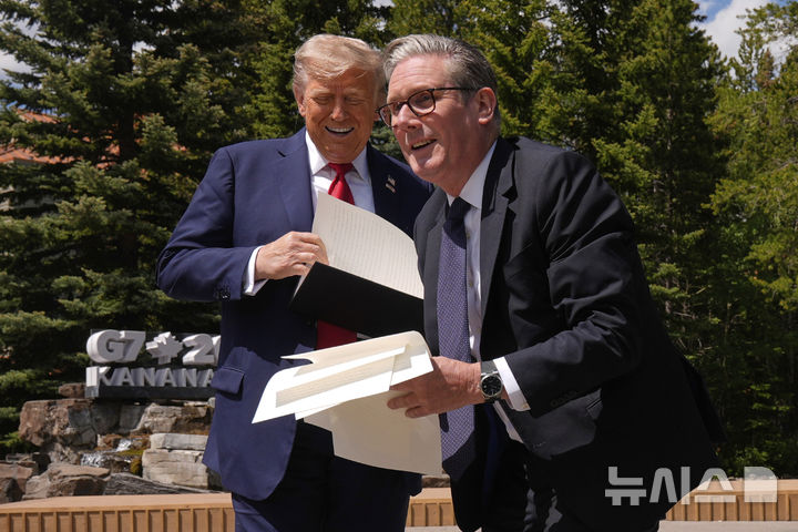 [카나나스키스=AP/뉴시스] 도널드 트럼프(왼쪽) 미국 대통령이 16일(현지 시간) 캐나다 카나나스키스에서 주요 7개국(G7) 정상회의를 계기로 키어 스타머 영국 총리와 회담 후 기자회견 하면서 행정명령 관련 서류를 떨어뜨리자 스타머 총리가 이를 주워주고 있다. 2025.06.17.