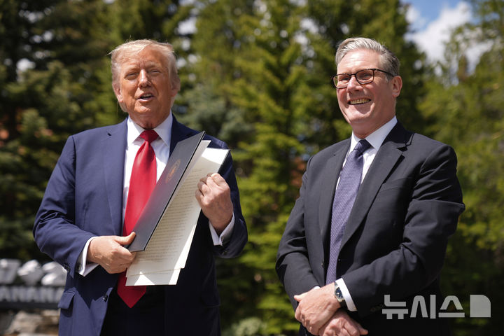 [카나나스키스=AP/뉴시스] 도널드 트럼프(왼쪽) 미국 대통령이 16일(현지 시간) 캐나다 카나나스키스에서 주요 7개국(G7) 정상회의를 계기로 키어 스타머 영국 총리와 회담 후 기자회견 하면서 떨어뜨린 행정명령 관련 서류를 정리하고 있다. 2025.06.17.