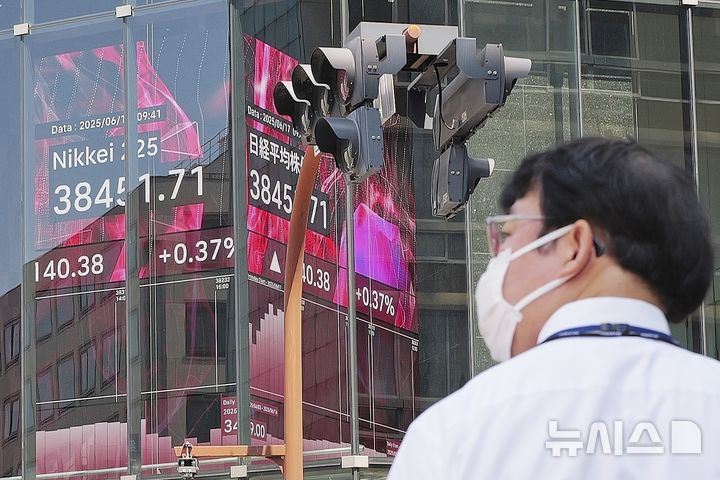[도쿄=AP/뉴시스]지난 6월17일 일본 도쿄의 한 증권사 전광판 앞을 시민이 지나하고 있다. 2025.06.18.