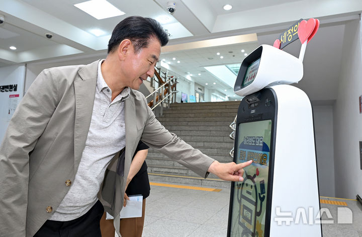 [의정부=뉴시스] 김동근 경기 의정부시장이 인공지능 기반 지방세 안내 로봇 시연회에서 로봇의 주요 기능 등을 확인하고 있다.(사진=의정부시 제공).photo@newsis.com