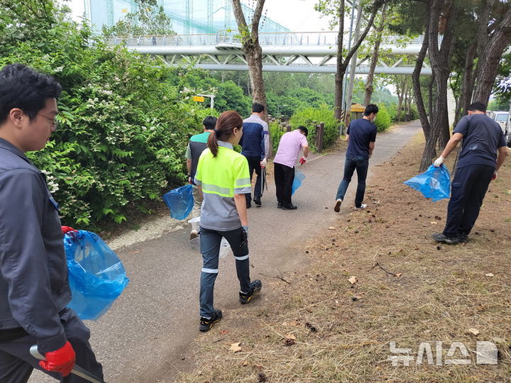 [시흥=뉴시스] 산업단지 주변 정화 참가자들이 쓰레기를 줍는 등 활동을 벌이고 있다. (사진=시흥시 제공).2025.06.17.photo@newsis.com
