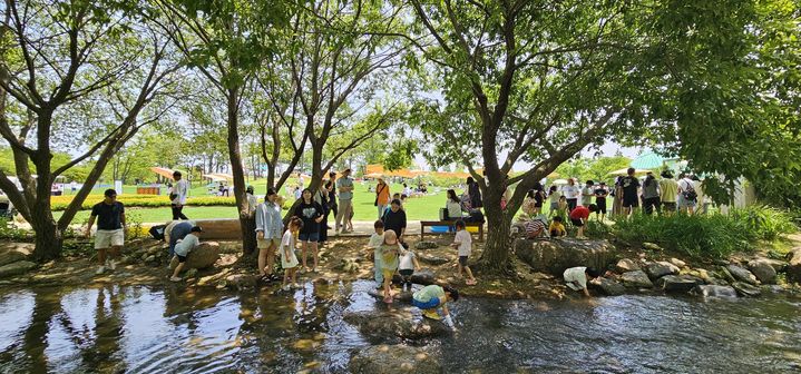 [순천=뉴시스] 순천만국가정원 개울길 광장에서 아이를 동반한 가족단위 나들이객이 휴식을 하고 있다. (사진=순천시 제공) 2025.06.17. photo@newsis.com *재판매 및 DB 금지