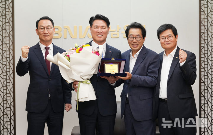 [창원=뉴시스]지난 16일 BNK경남은행 창원 본점에서 김태한(왼쪽서 두 번째) 은행장이 경상남도육상연맹 장운익 선거운영위원장으로부터 회장 당선패를 전달받고 있다.(사진=BNK경남은행 제공) 2025.06.17. photo@newsis.com