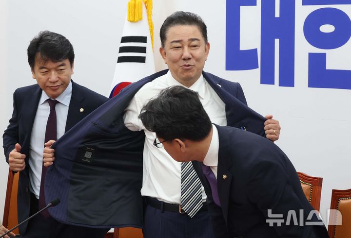 [서울=뉴시스] 조성봉 기자 = 김병기 더불어민주당 당대표 직무대행 겸 원내대표가 17일 오전 서울 여의도 국회에서 열린 원내대책회의에 앞서 외투를 벗고 있다. 2025.06.17. suncho21@newsis.com