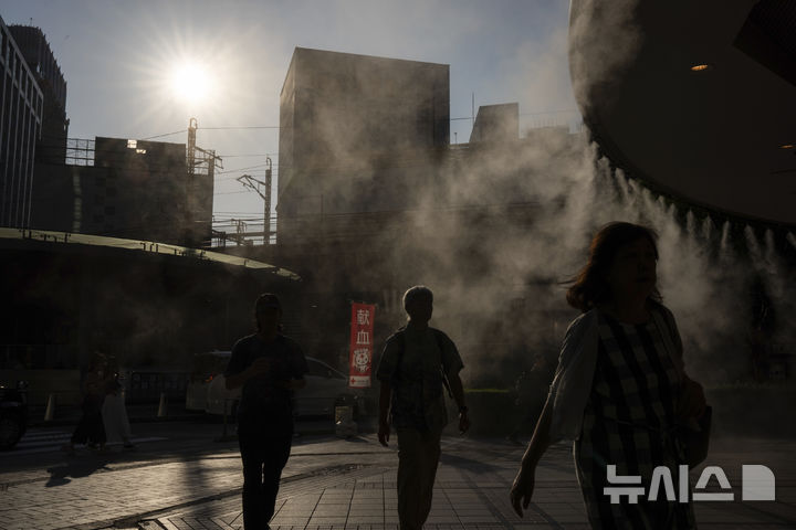 [도쿄=AP/뉴시스]지난 6월 17일 일본 도쿄에서 시민들이 더위를 식히기 위한 안개 분사 시설 아래 걸어가고 있다. 2025.07.28.