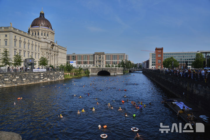 [베를린=AP/뉴시스] 17일(현지 시간) 독일 베를린 슈프레강에서 시민들이 수영 금지 해제를 촉구하며 수영하고 있다. 슈프레강은 수질 오염에 따른 보건 위험으로 100년 넘게 수영이 금지됐으며 강물과 분리된 부유식 수영장만 운영되고 있다. 시민 주도 비영리단체 '플루스바트 베를린'은 슈프레강이 수영할 만큼 수질이 개선됐다면서 수영 허용을 촉구하고 있다. 2025.06.18.