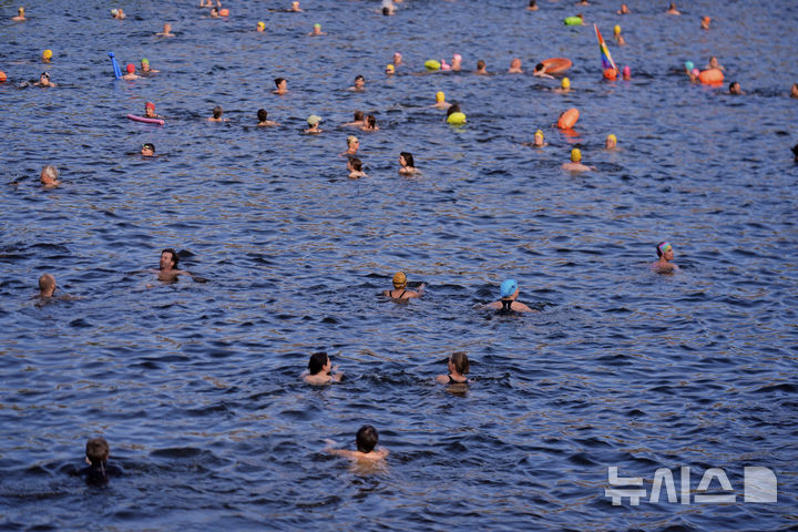 [베를린=AP/뉴시스] 17일(현지 시간) 독일 베를린 슈프레강에서 시민들이 수영 금지 해제를 촉구하며 수영하고 있다. 슈프레강은 수질 오염에 따른 보건 위험으로 100년 넘게 수영이 금지됐으며 강물과 분리된 부유식 수영장만 운영되고 있다. 시민 주도 비영리단체 '플루스바트 베를린'은 슈프레강이 수영할 만큼 수질이 개선됐다면서 수영 허용을 촉구하고 있다. 2025.06.18.
